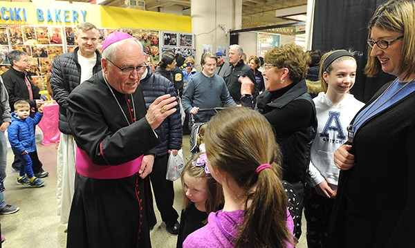 Bishop Richard J. Malone blesses a family during a visit to the Broadway Market on Saturday morning. (Dan Cappellazzo/Staff Photographer)